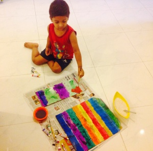 He asked me to make paper bags, so we could utilise the tube colors well. And here he is putting his art to work! The bigger one was done by me, suggested by Arin. Now he keeps his colors and book in these bags.